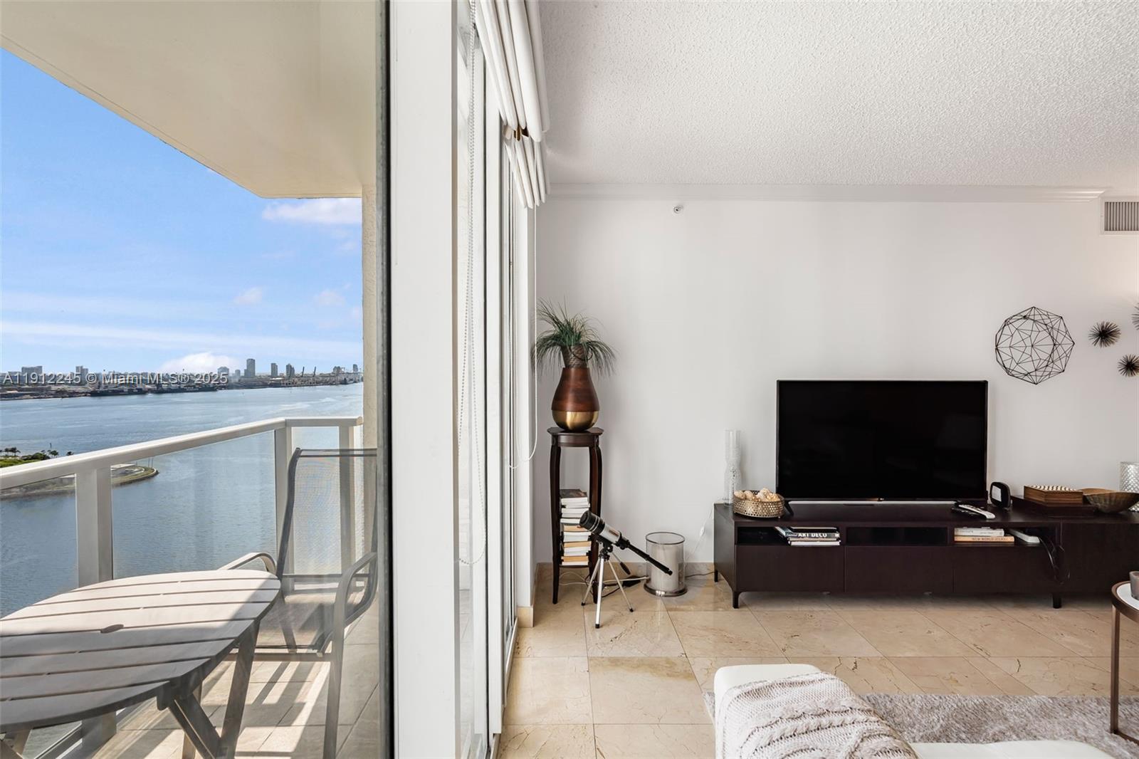 1155 Brickell Bay Drive, Unit 2708 Miami, FL 33131 - Photo 3 of 19 a living room with furniture and a flat screen tv