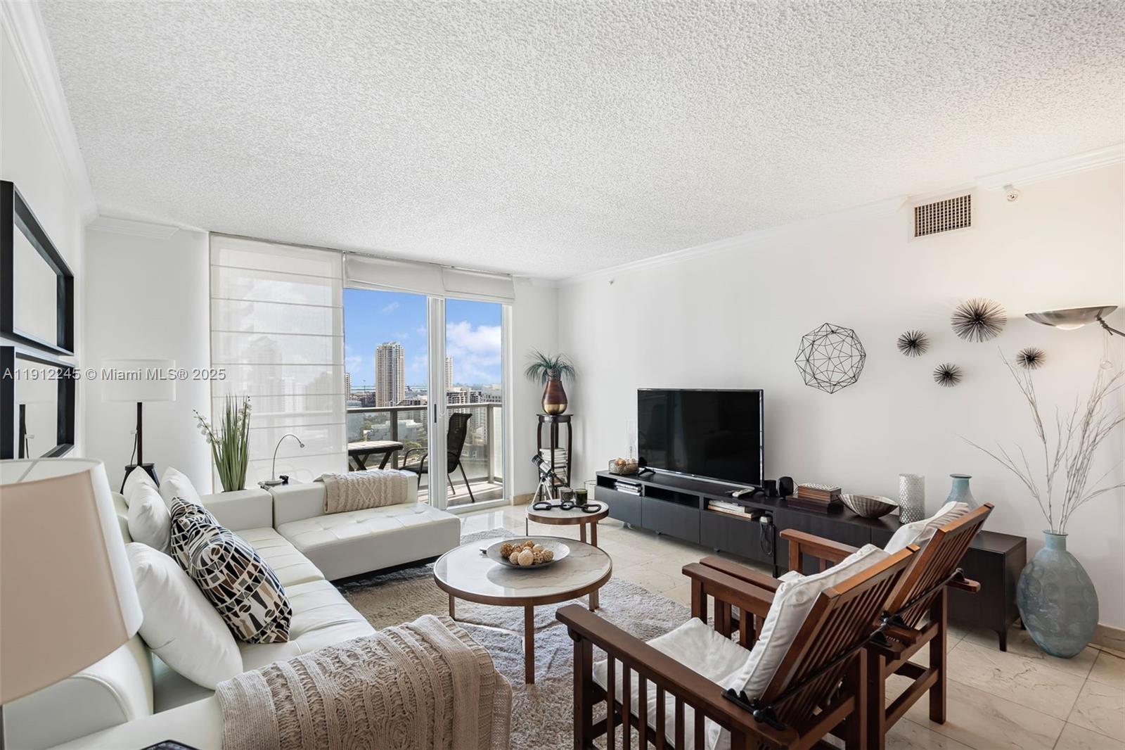 1155 Brickell Bay Drive, Unit 2708 Miami, FL 33131 - Photo 6 of 19 a living room with furniture a flat screen tv and a table