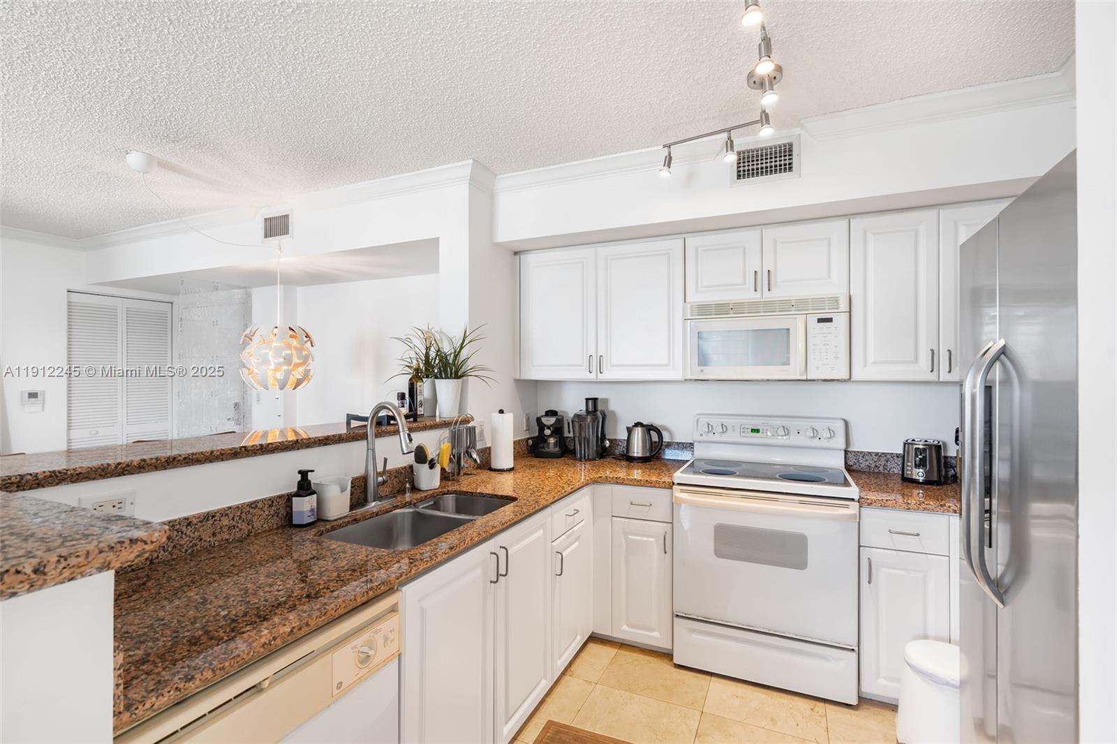 1155 Brickell Bay Drive, Unit 2708 Miami, FL 33131 - Photo 9 of 19 a kitchen with a sink stove and refrigerator