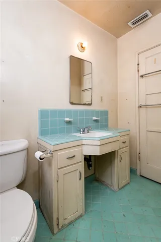a bathroom with a toilet sink and mirror