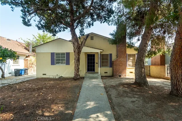 a front view of a house with a yard and trees