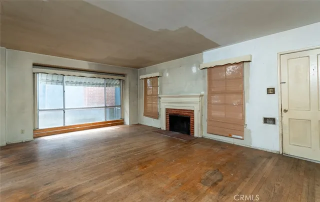 an empty room with windows and fireplace