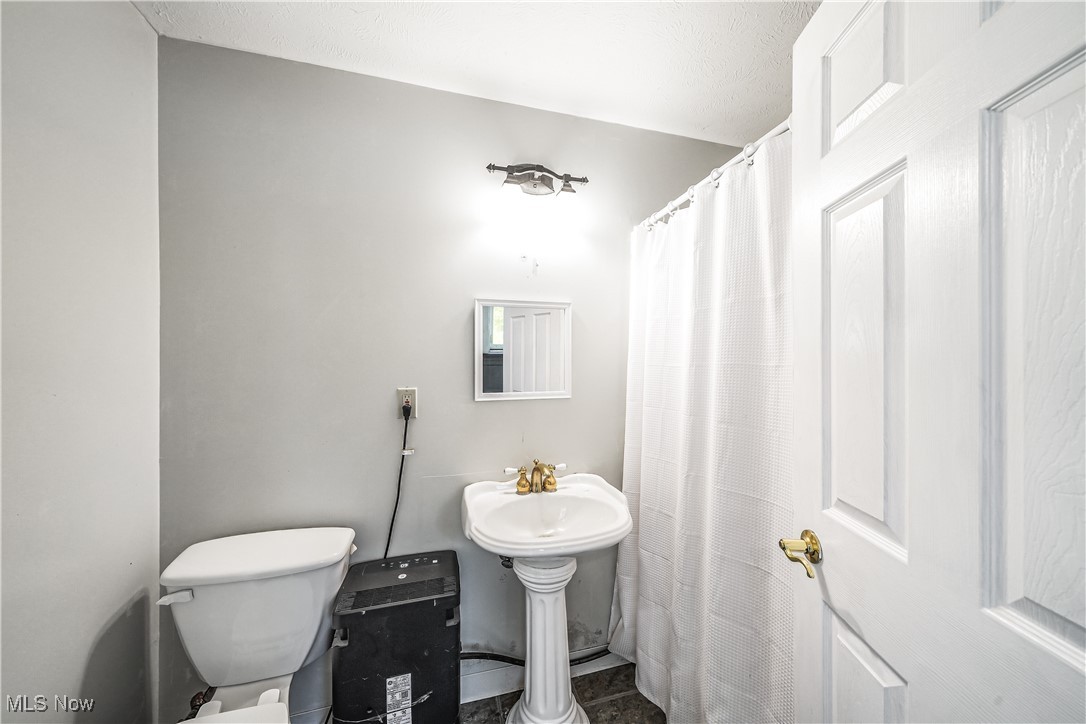6916 Dewey Road Thompson, OH 44086 - Photo 14 of 49 Bathroom featuring tile patterned flooring and a shower with curtain