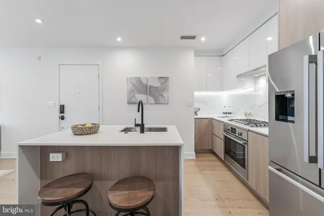 a kitchen with stainless steel appliances granite countertop a sink a stove and a refrigerator