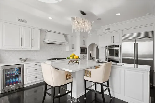 a kitchen with stainless steel appliances kitchen island granite countertop a table chairs microwave and sink