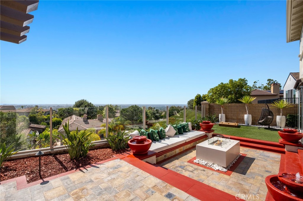 17 Lemans Newport Coast, CA 92657 - Photo 13 of 40 a view of a patio with couches table and chairs under an umbrella next to a yard