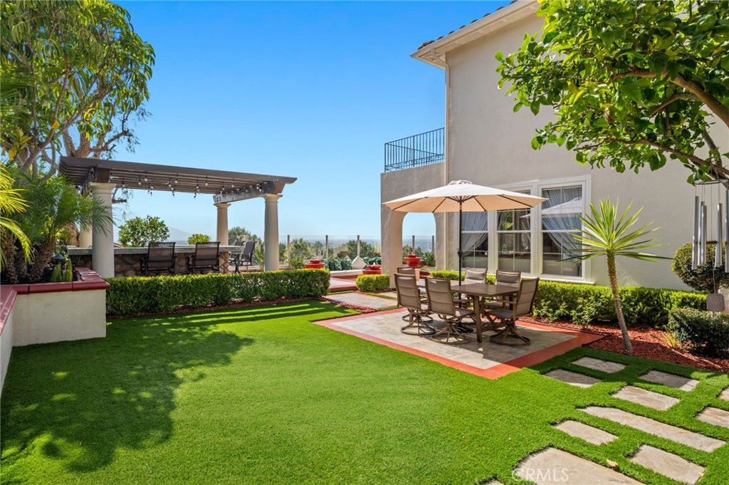 17 Lemans Newport Coast, CA 92657 - Photo 2 of 40 a view of a patio with couches table and chairs under an umbrella with a garden