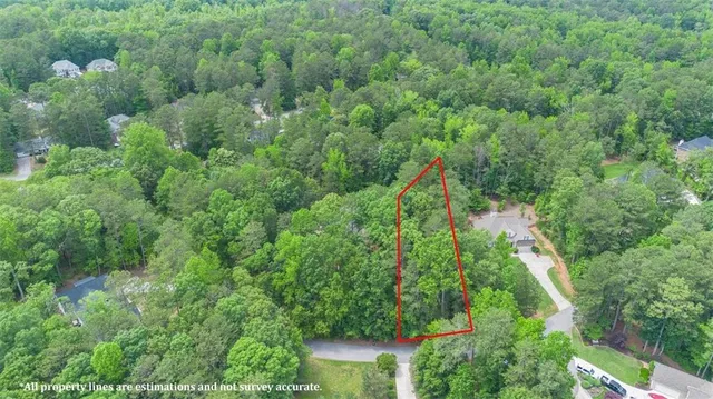 an aerial view of residential house with outdoor space and trees all around