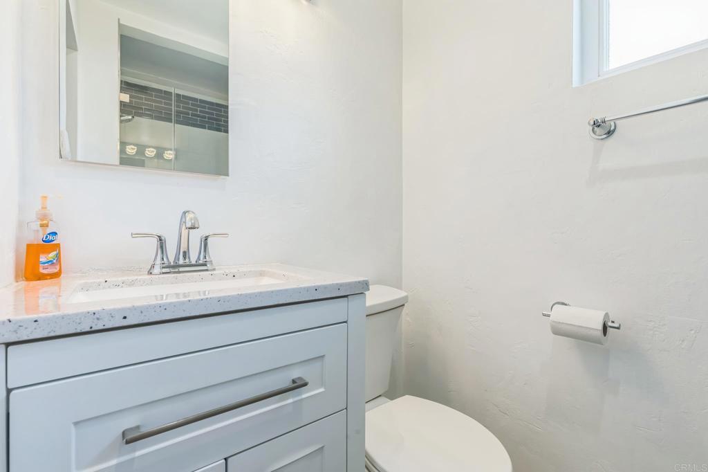 1350 Coy Court El Cajon, CA 92021 - Photo 24 of 30 a bathroom with a granite countertop toilet sink mirror and vanity
