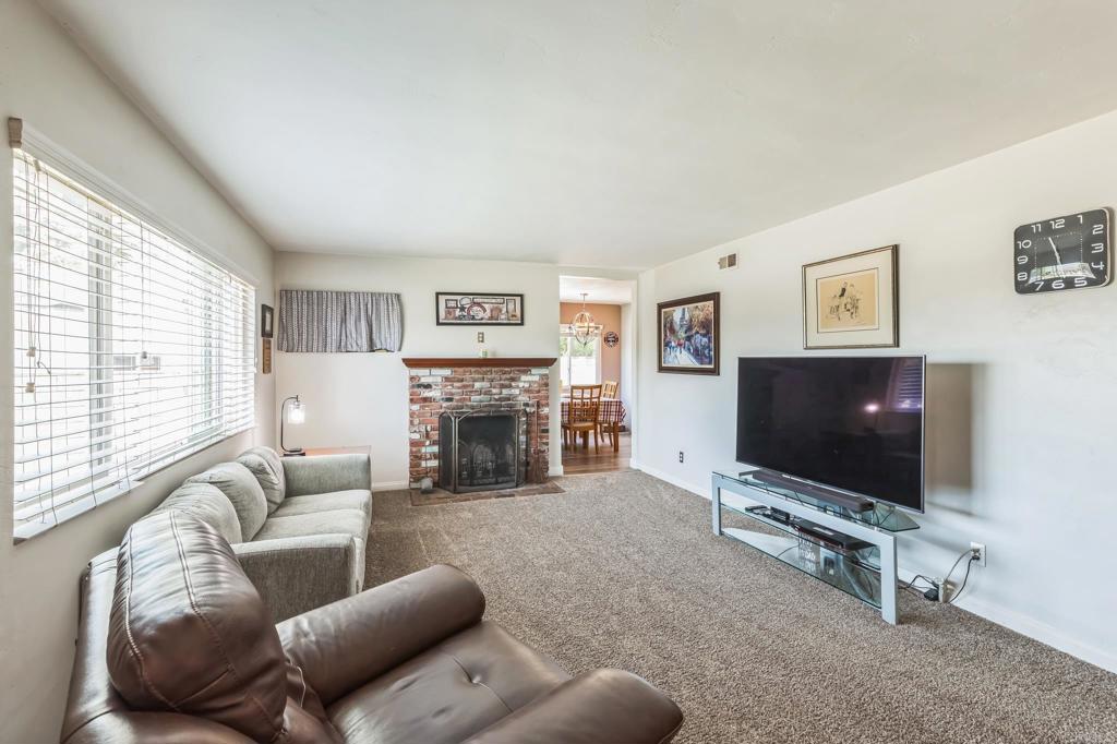 1350 Coy Court El Cajon, CA 92021 - Photo 8 of 30 a living room with furniture a flat screen tv and a fireplace