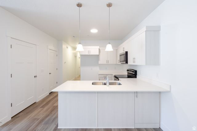 675 West 4500th South, Unit P204 Mapleton, UT 84664 - Photo 14 of 16 Modern kitchen featuring white cabinetry, light-toned countertops, and stainless steel sink