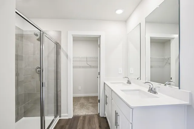 a bathroom with a double vanity sink mirror and shower