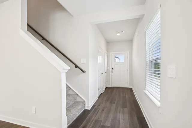 a view of a hallway with wooden floor and staircase