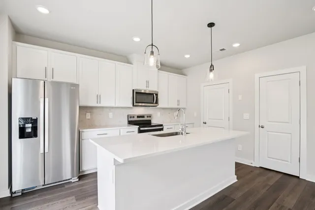 a kitchen with stainless steel appliances a refrigerator sink and microwave