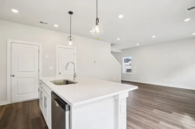 a kitchen with a sink a counter space and wooden floor