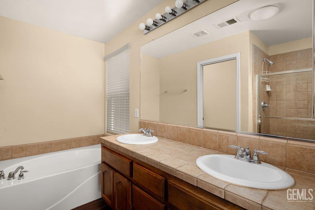 Undisclosed Address Bakersfield, CA 93312 - Photo 12 of 21 a bathroom with a granite countertop sink and a mirror