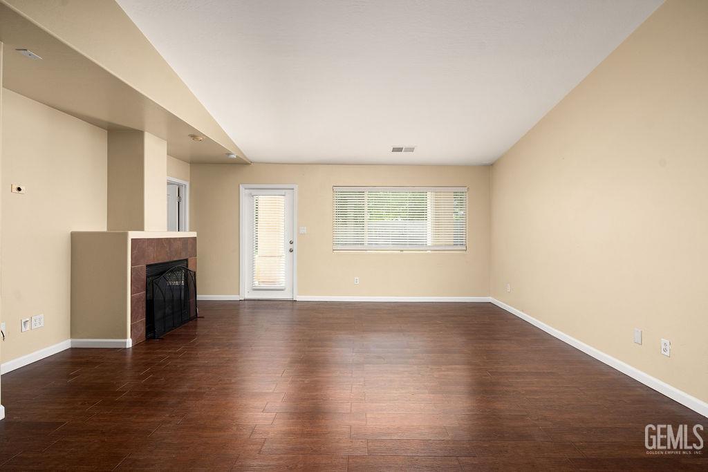 Undisclosed Address Bakersfield, CA 93312 - Photo 13 of 21 an empty room with wooden floor fireplace and windows