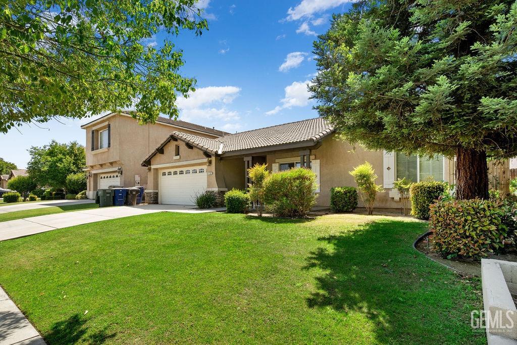Undisclosed Address Bakersfield, CA 93312 - Photo 3 of 21 a front view of a house with a yard and garage