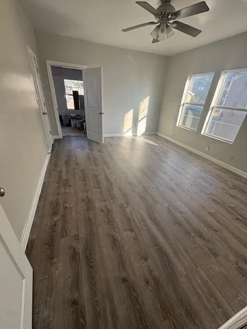 a view of a livingroom with wooden floor and staircase
