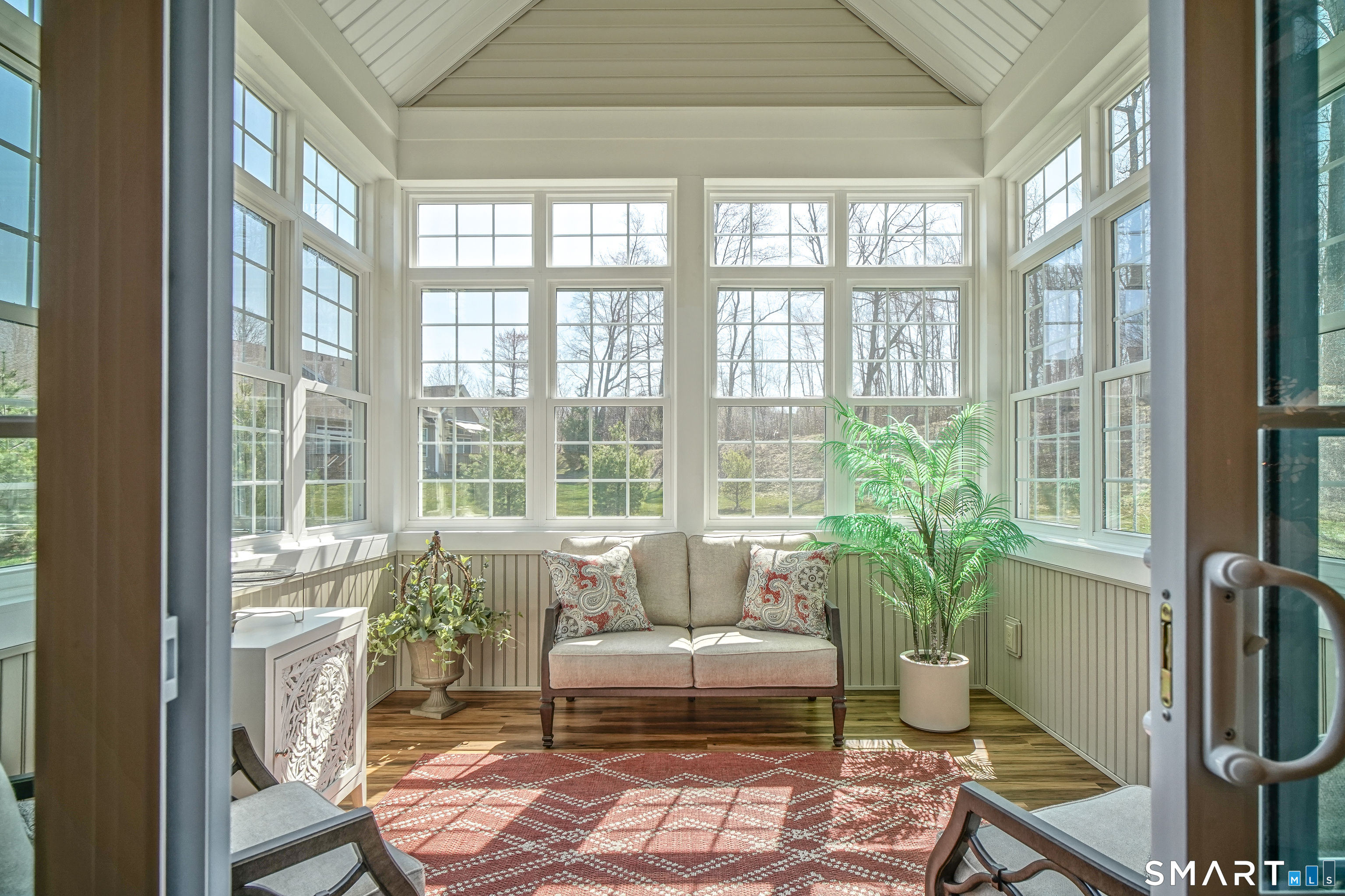 28 Tamarack Court, Unit 28 Prospect, CT 06712 - Photo 10 of 40 Enjoy a 3-season room with high windows, wainscoating, and sliding doors.
