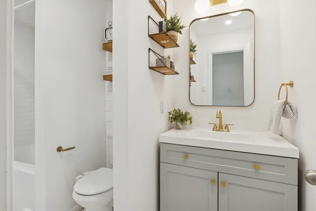 a bathroom with a toilet sink and mirror