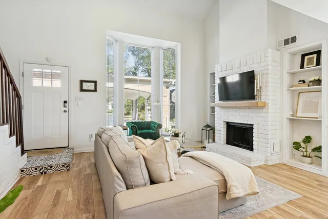 a living room with furniture a flat screen tv and a fireplace