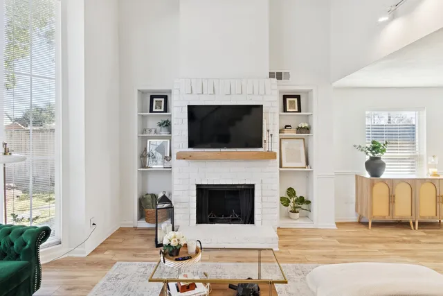 a living room with furniture a flat screen tv and a fireplace