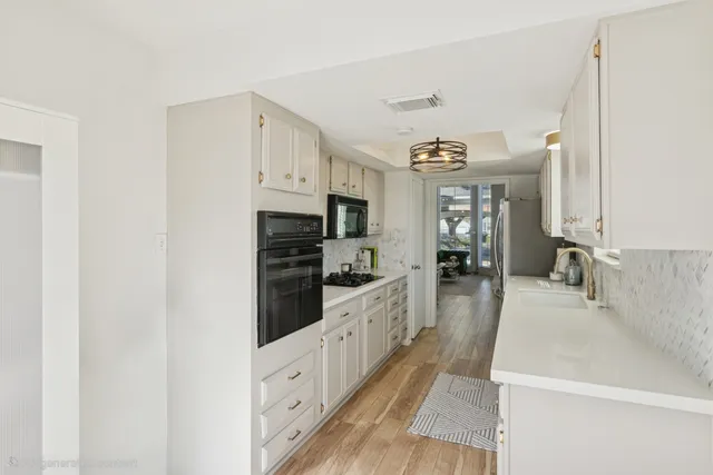 a large kitchen with kitchen island a large counter top space a sink stainless steel appliances and cabinets