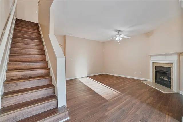 a view of an empty room with wooden floor and a fireplace