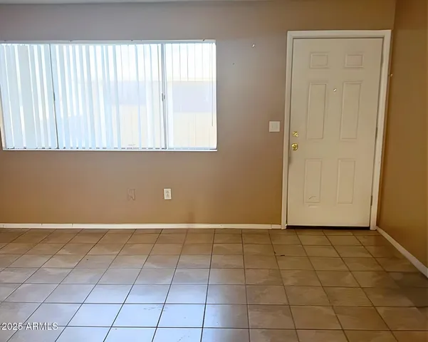 a view of a livingroom with an empty space and a window