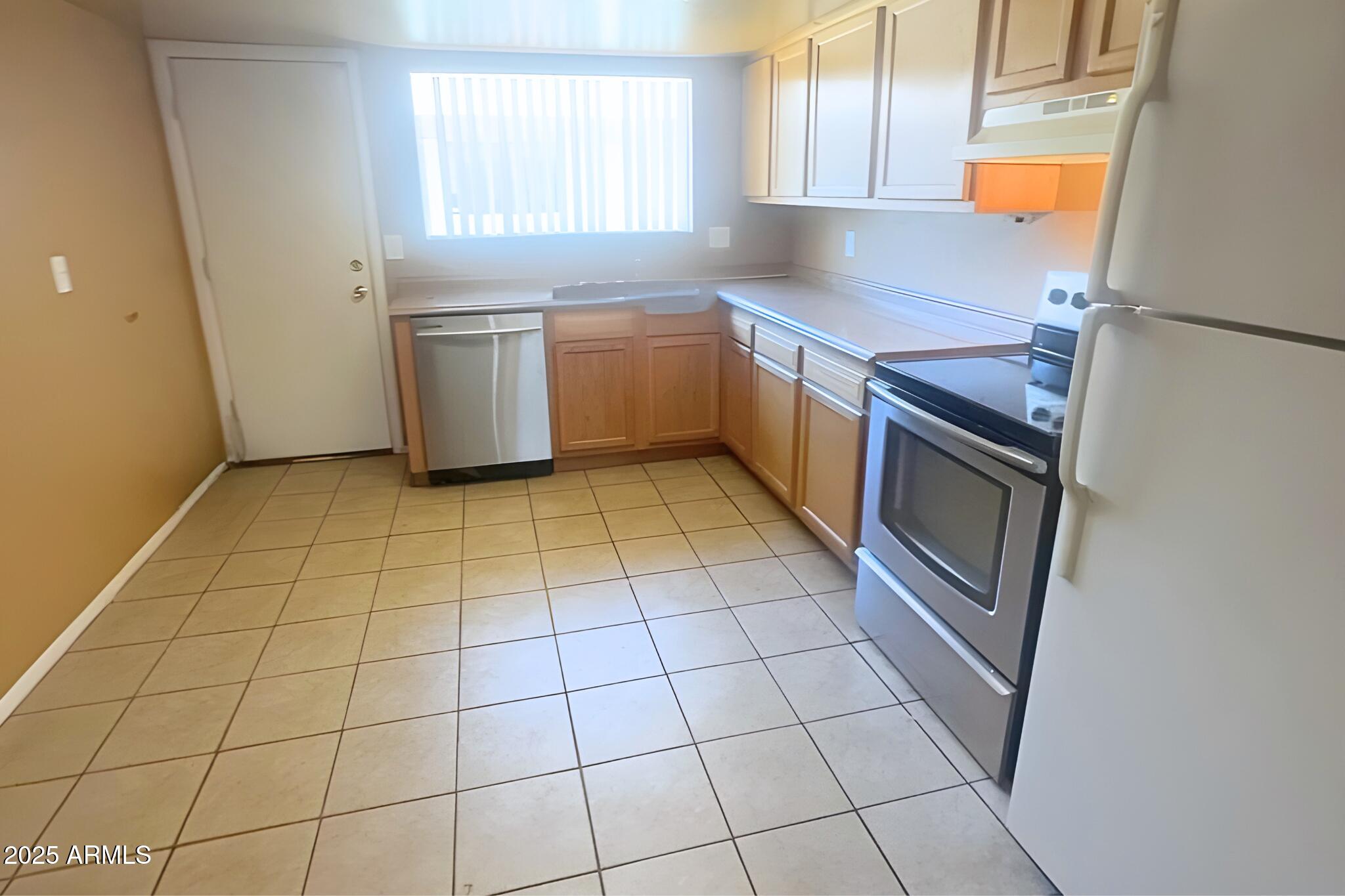 3313 West Harmont Drive, Unit 3 Phoenix, AZ 85051 - Photo 3 of 7 a kitchen with stainless steel appliances a sink and a cabinets