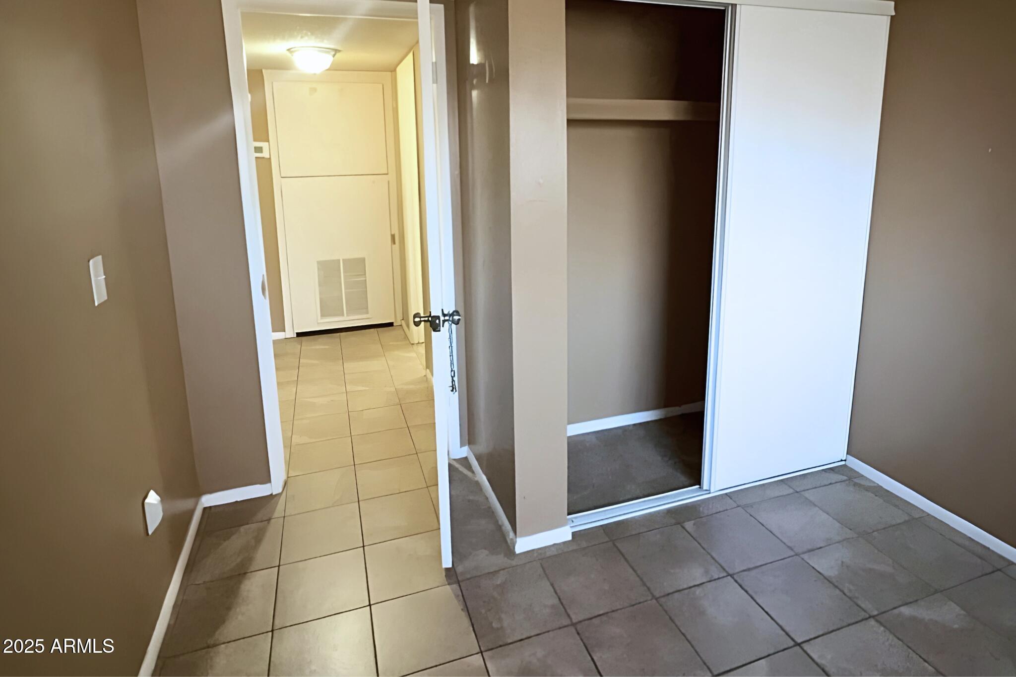 3313 West Harmont Drive, Unit 3 Phoenix, AZ 85051 - Photo 6 of 7 a view of a refrigerator in kitchen and an empty room