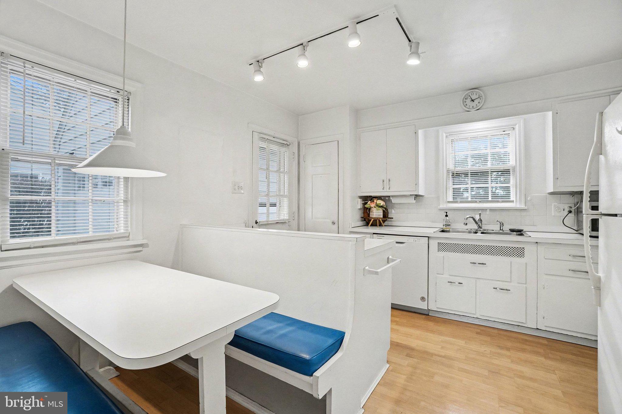 3603 Hillcrest Road Harrisburg, PA 17109 - Photo 10 of 34 a kitchen with a stove a sink dishwasher a dining table and chairs with wooden floor