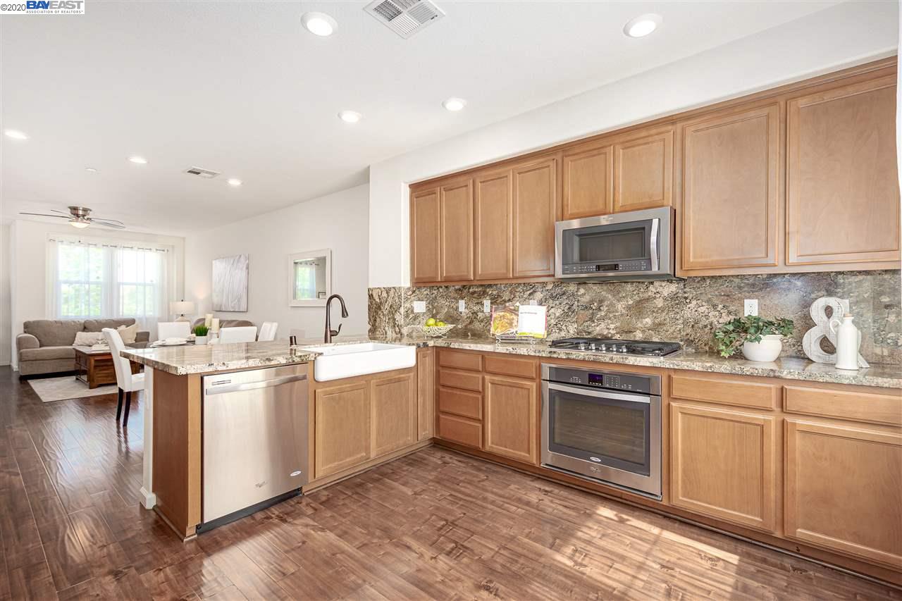 Gourmet kitchen with farmhouse sink, stainless appliances, granite counters, and  cabinetry