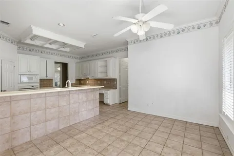 an empty room with chandelier fan