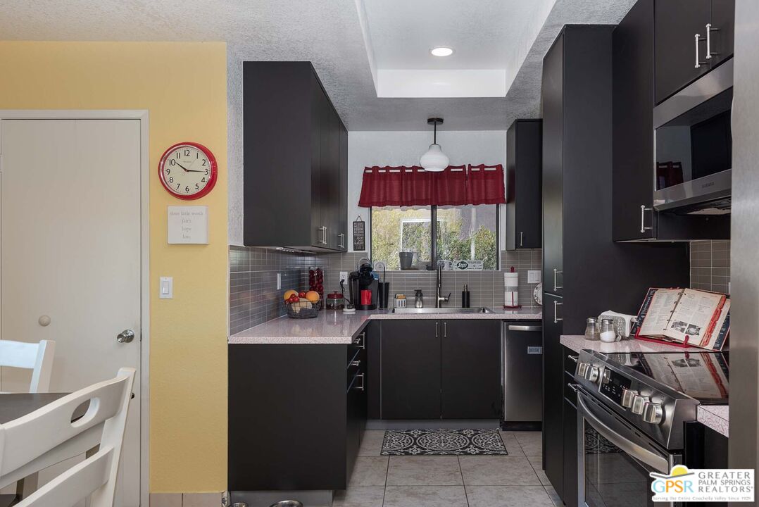 9760 Capiland Road Desert Hot Springs, CA 92240 - Photo 7 of 16 a kitchen with a sink and a stove top oven