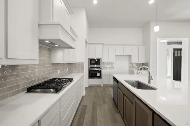 a kitchen with a sink a stove and cabinets