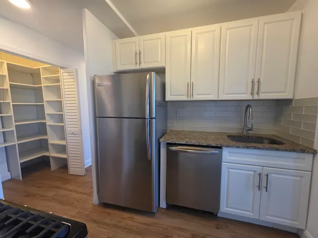 a kitchen with stainless steel appliances granite countertop a refrigerator and a stove top oven
