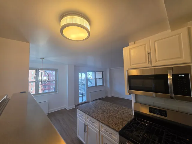 a kitchen with stainless steel appliances granite countertop a stove a microwave and cabinets