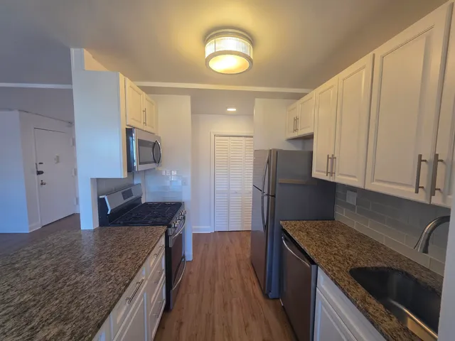 a kitchen with stainless steel appliances granite countertop a sink stove and refrigerator