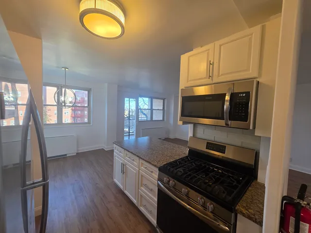 a kitchen with stainless steel appliances granite countertop a stove microwave and sink