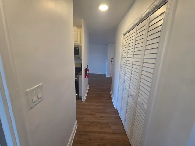 a view of a hallway with wooden floor and closet
