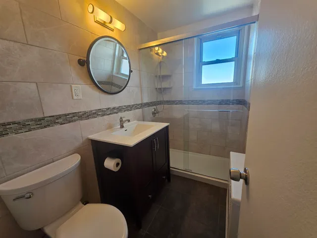 a bathroom with a sink mirror vanity and toilet