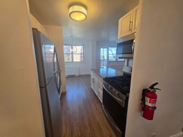 a kitchen with granite countertop a refrigerator a stove top oven a sink and dishwasher