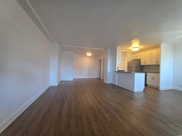 a view of a kitchen with wooden floor and a kitchen