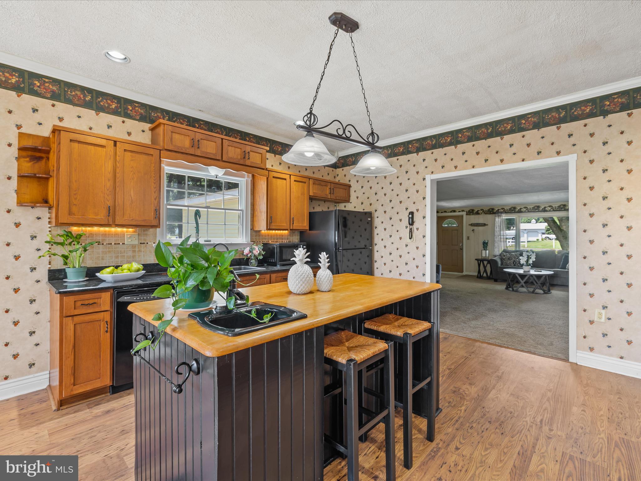 28495 Fire Tower Road Laurel, DE 19956 - Photo 9 of 31 a kitchen with stainless steel appliances granite countertop a sink a stove a refrigerator a dining table and chairs with wooden floor
