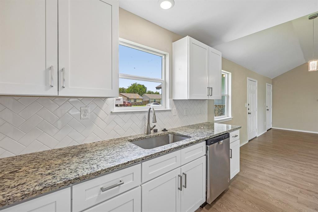 433 Whitney Court Rio Vista, TX 76093 - Photo 12 of 27 a kitchen with granite countertop white cabinets and a sink