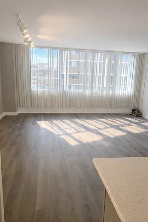 a view of an empty room with wooden floor