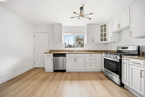 a kitchen with a sink cabinets stainless steel appliances and a window