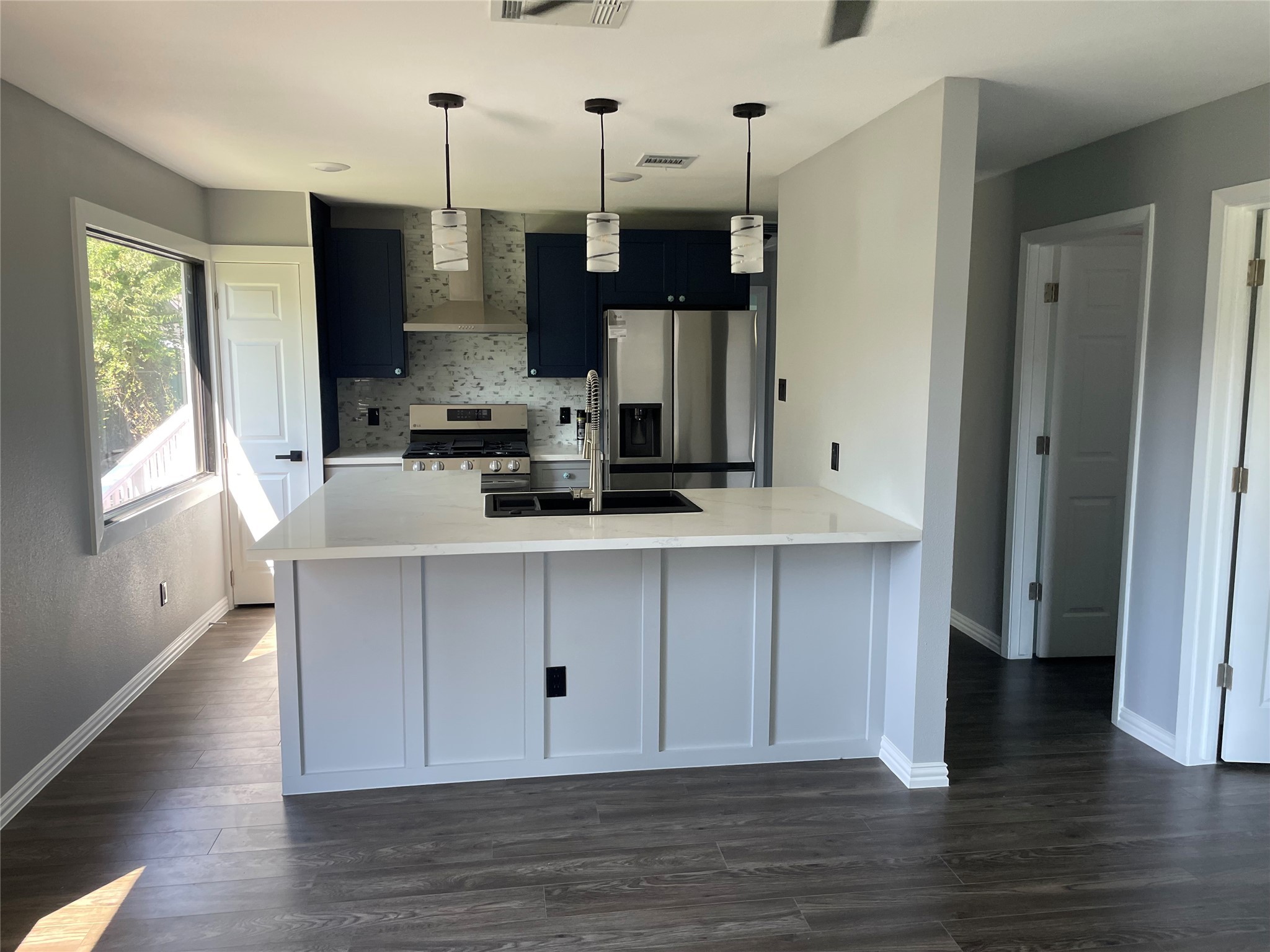 2709 Terry Street Houston, TX 77009 - Photo 8 of 23 a kitchen with stainless steel appliances a sink stove and wooden floor